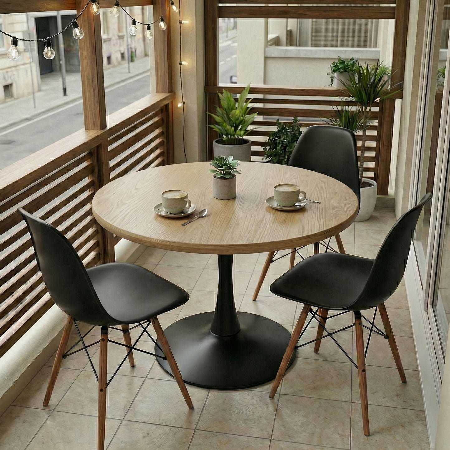 Round wooden table with black chairs on a balcony with plants and string lights.